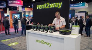 Rent2Way trade show booth featuring rented iPhones and staff managing tech equipment display
